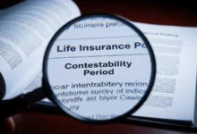 A magnifying glass highlighting the contestability period clause on a life insurance contract.
